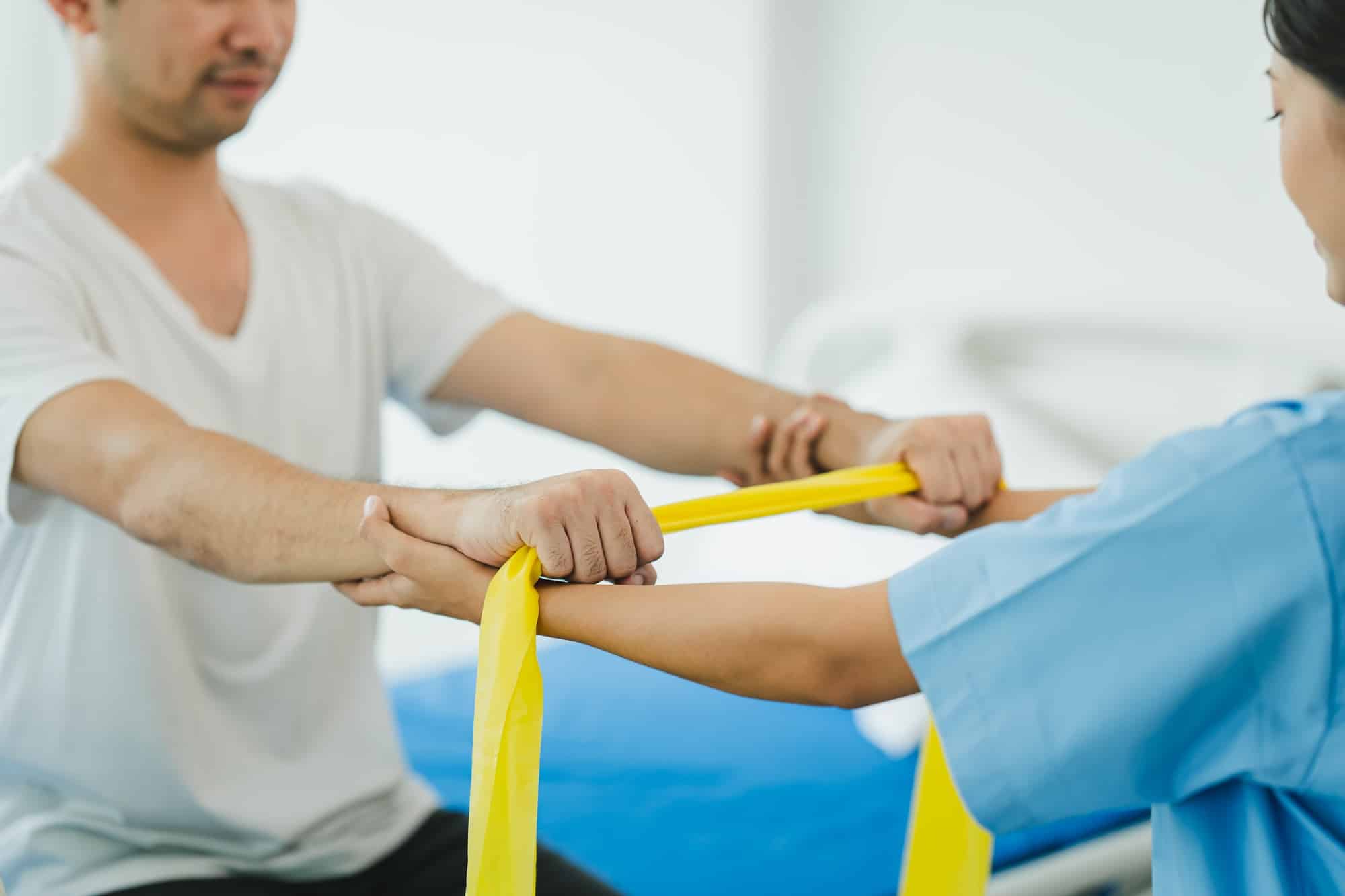 Physical therapist giving stretching exercises with elastic exercise bands and physical therapist ha